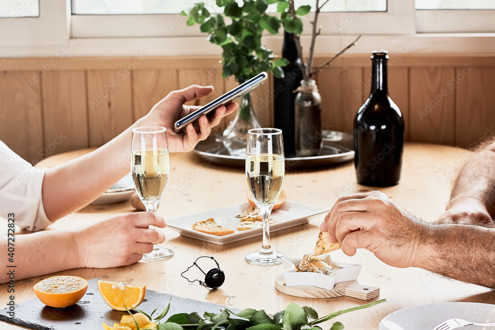 Couple of lovers having romantic lunch. Woman makes a photo with cellphone Selective focus.