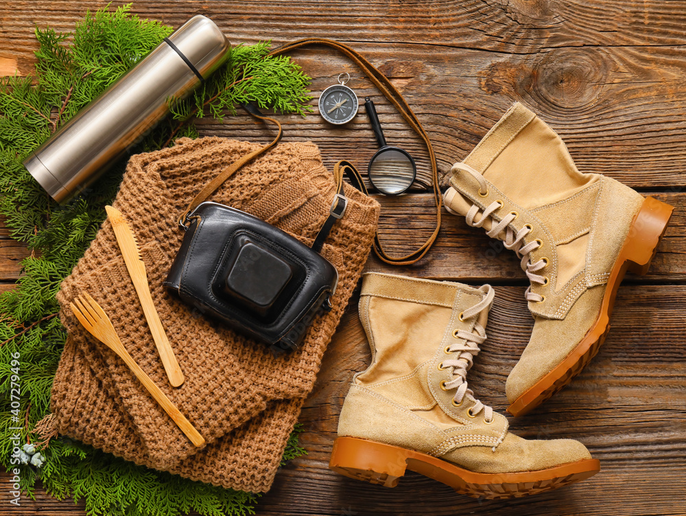 Composition with items and clothes for hiking on wooden background