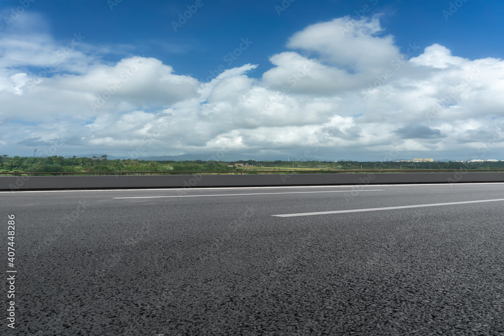 Asphalt ground and blue sky with white clouds