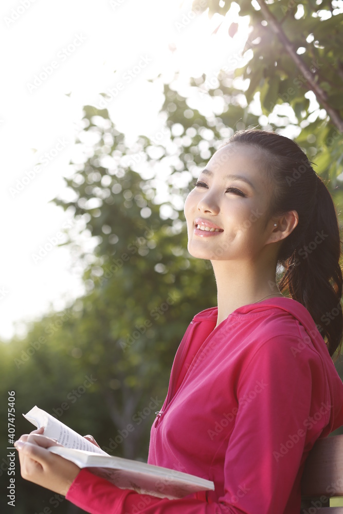 Young woman reading a Book outdoors 