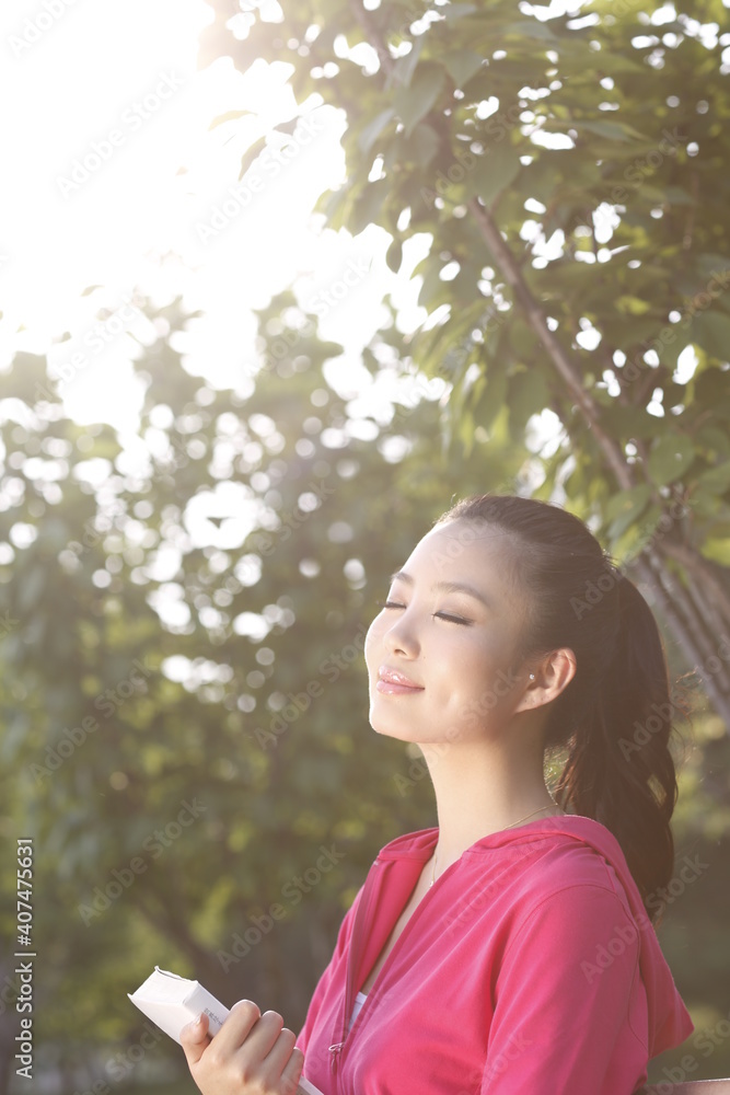 Young woman reading a Book outdoors 