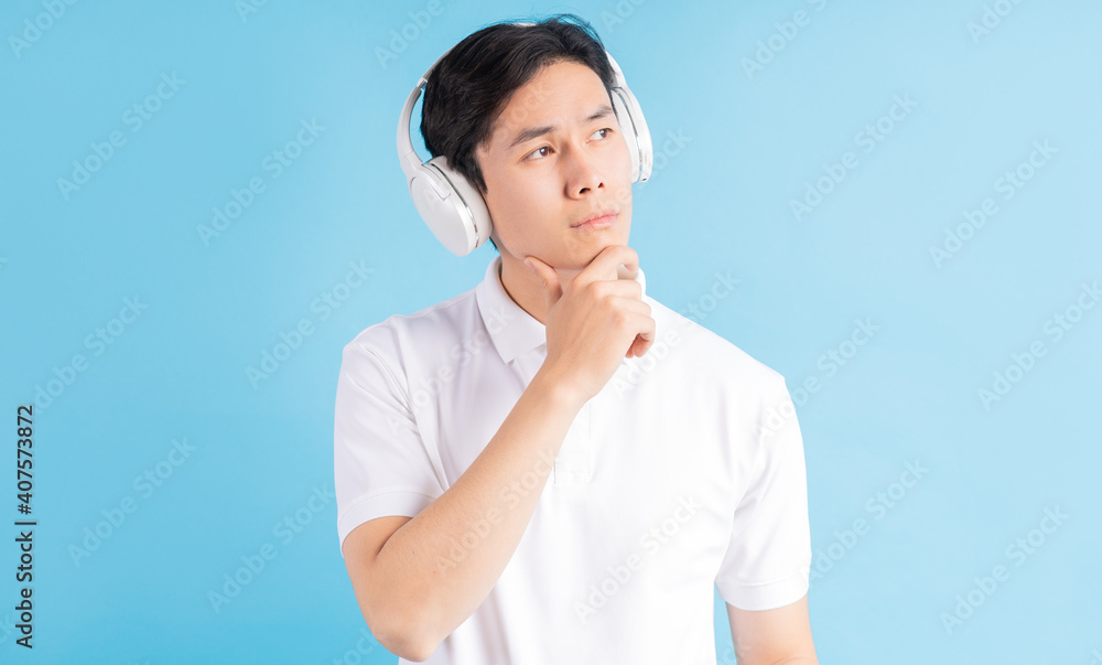 a photo of a handsome Asian boy listening to music and thinking