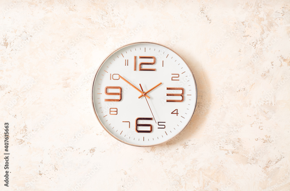 Modern clock hanging on light wall