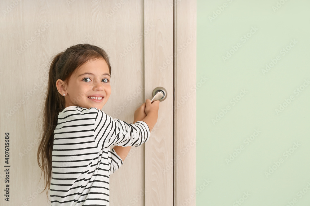 Cute little girl opening door