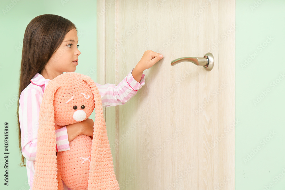 Cute little girl knocking at door