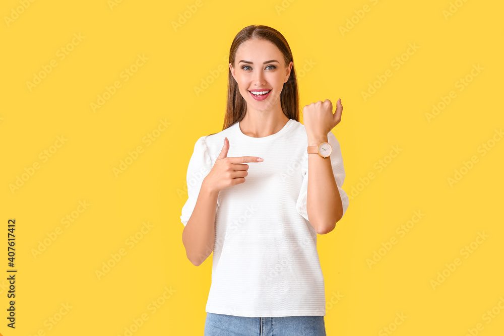 Beautiful woman with wristwatch on color background