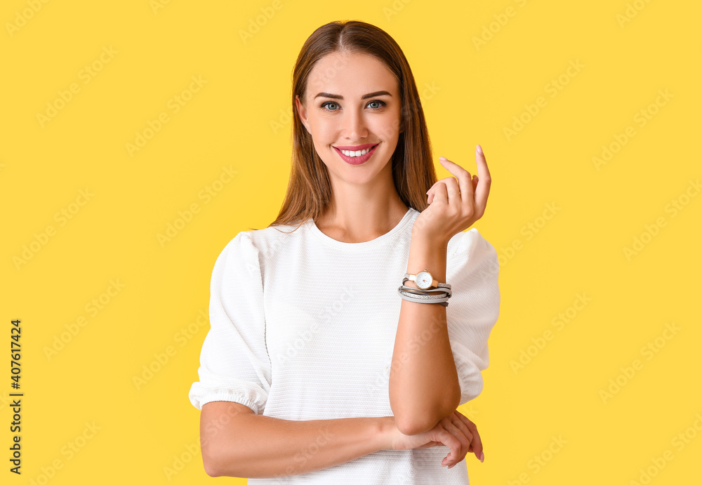 Beautiful woman with wristwatch on color background