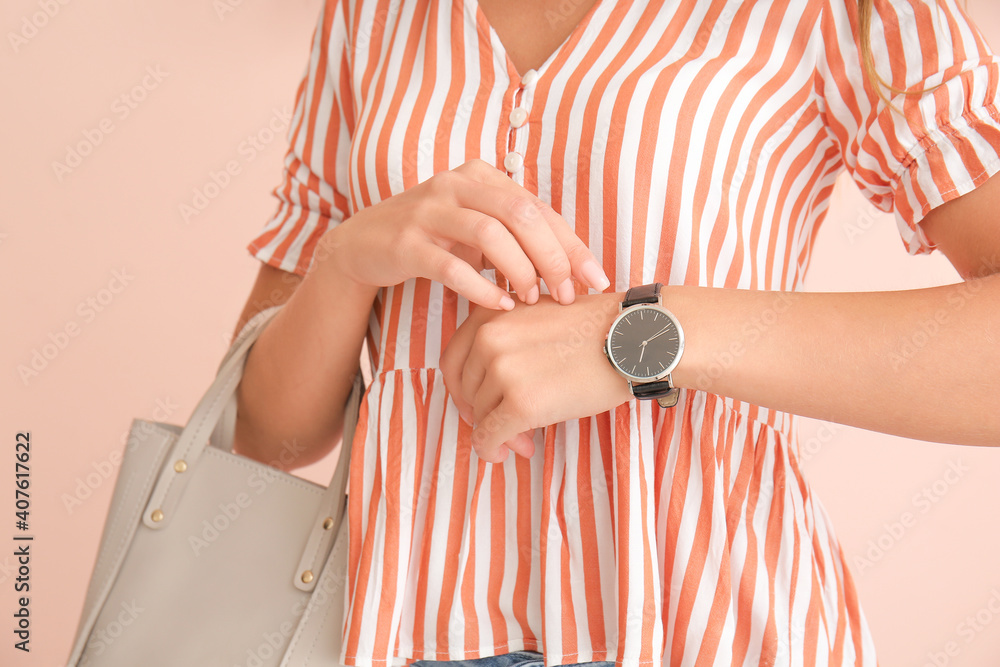 Woman with wristwatch on color background, closeup