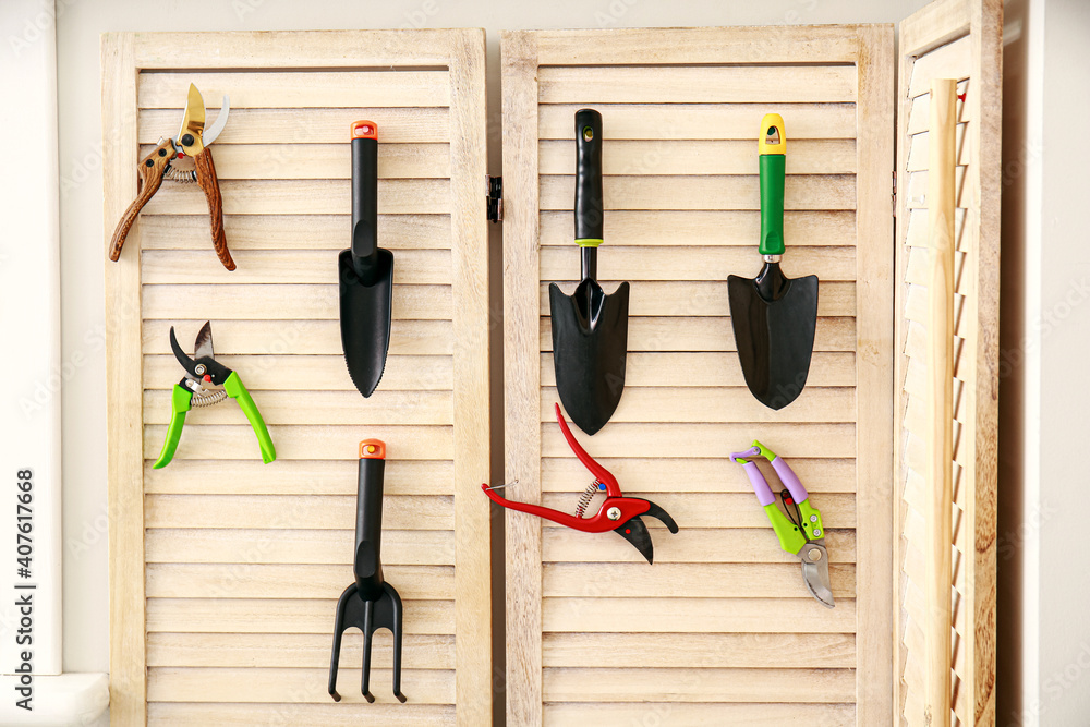 Different gardening supplies hanging on wall in barn