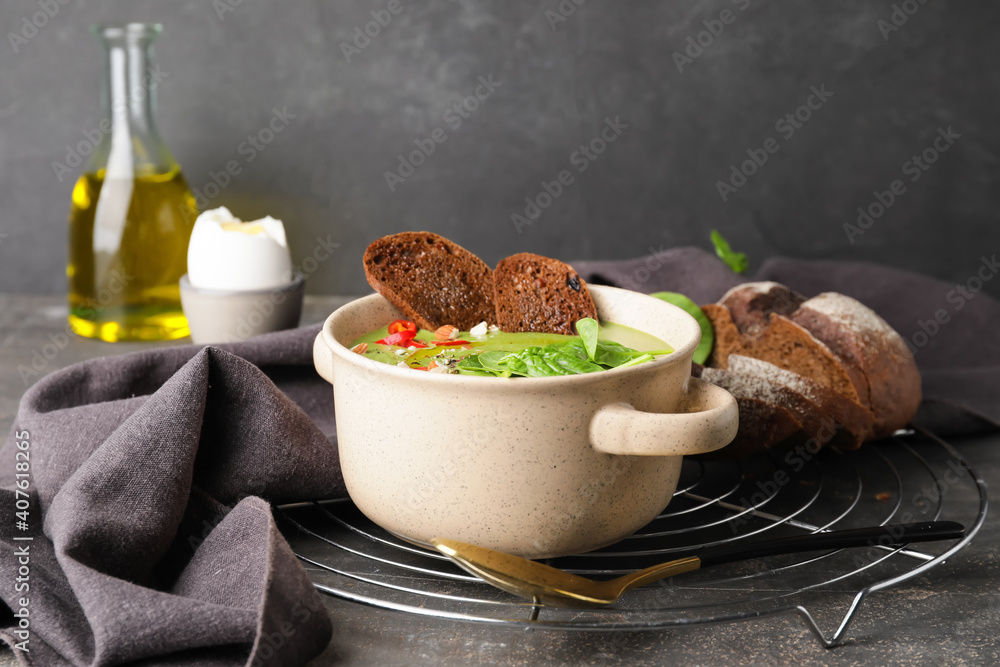 Bowl with tasty spinach soup on dark background