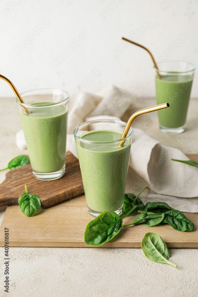 Glasses of healthy spinach smoothie on light table