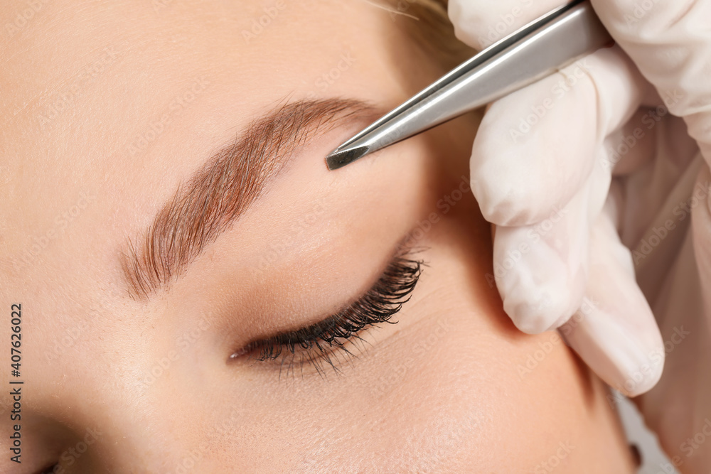 Young woman undergoing eyebrow correction procedure, closeup