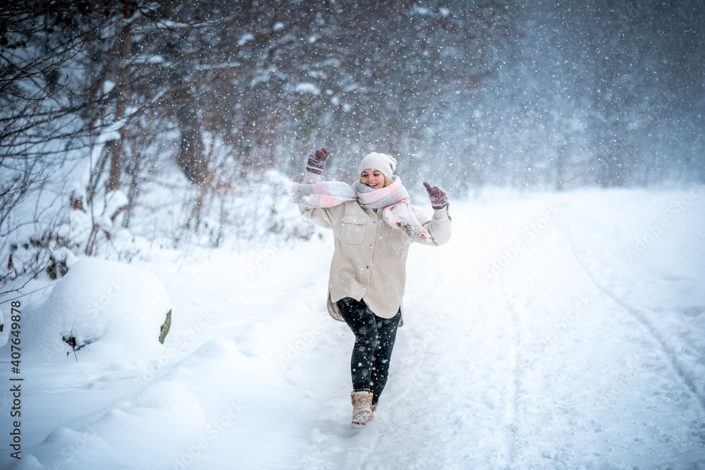 快乐的女孩享受着充满雪的美丽冬天