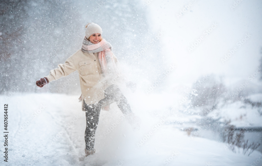 微笑的女人在户外雪地里享受冬天