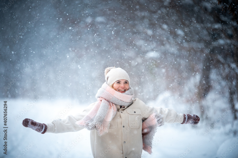 Winter portrait of young woman among snowy park