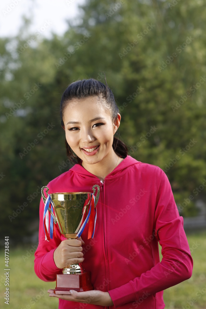 手持奖杯的年轻女子