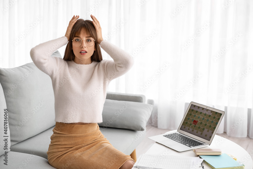 Stressed young woman trying to meet deadline at home