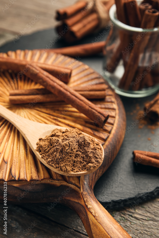 Cinnamon sticks and powder on wooden background