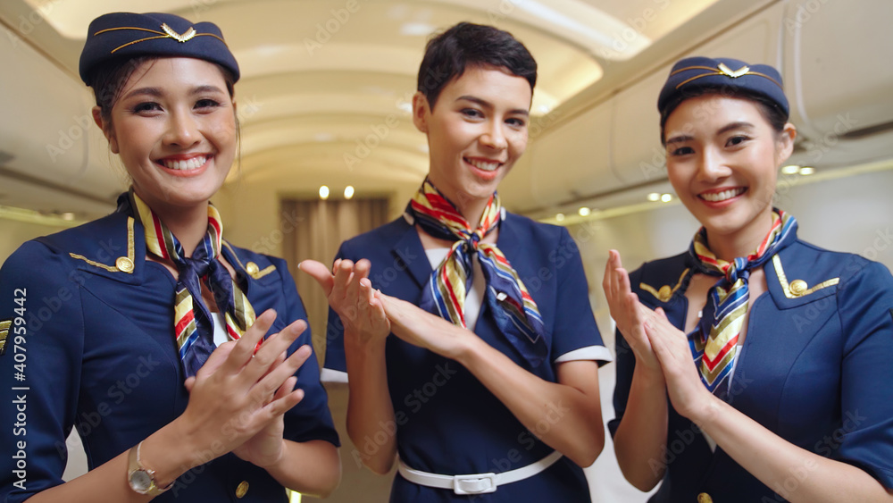 Cabin crew clapping hands in airplane . Airline transportation and tourism concept.