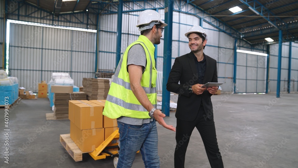 Factory workers deliver boxes package on a pushing trolley in the warehouse . Industry supply chain 