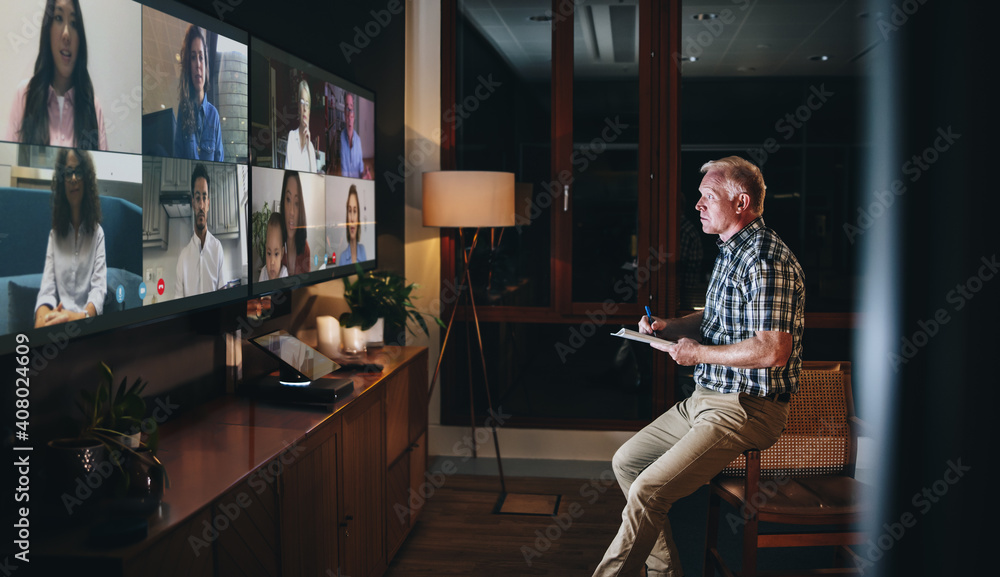 Businessman doing a video call at night with colleagues