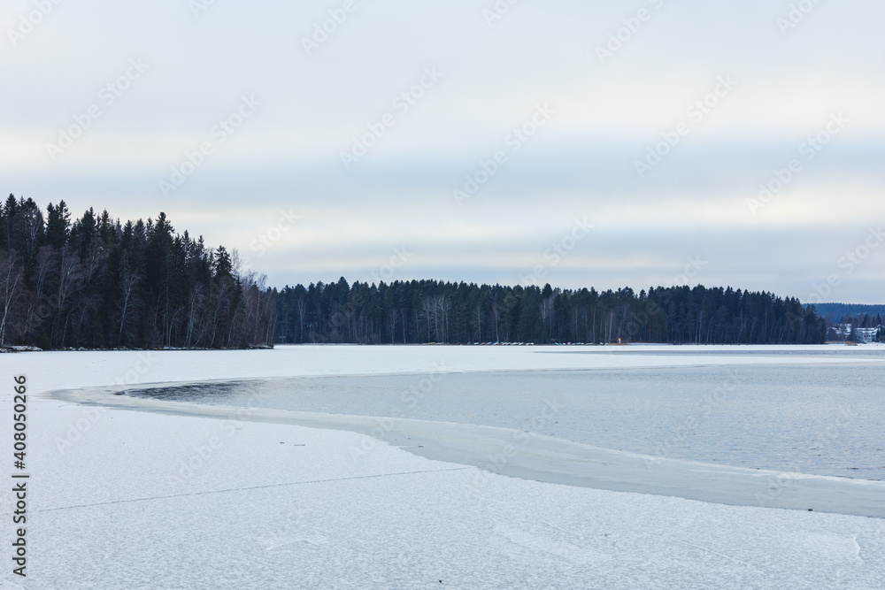 Partially frozen lake surface and snow