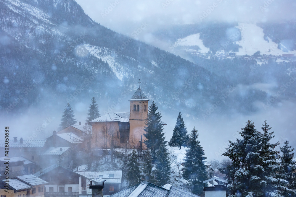 法国Champagny-en-Vanoise村的教堂和温镇大雪期间的库尔舍维尔景观