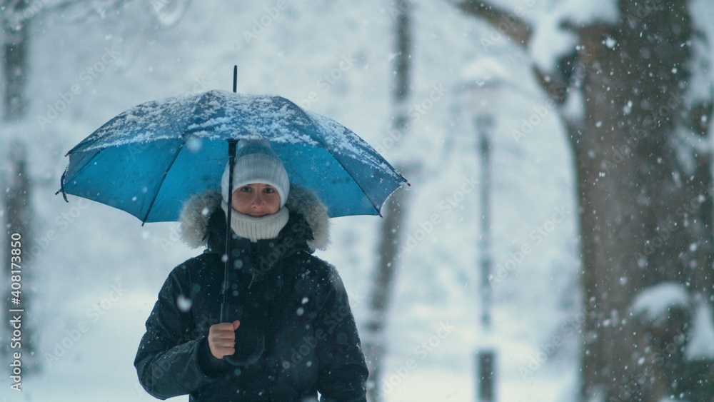 复制空间，肖像：一名女子在暴风雪中探索田园诗般的白色公园。