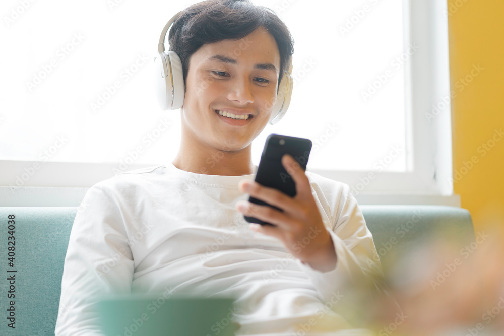 Asian man sitting, enjoying music