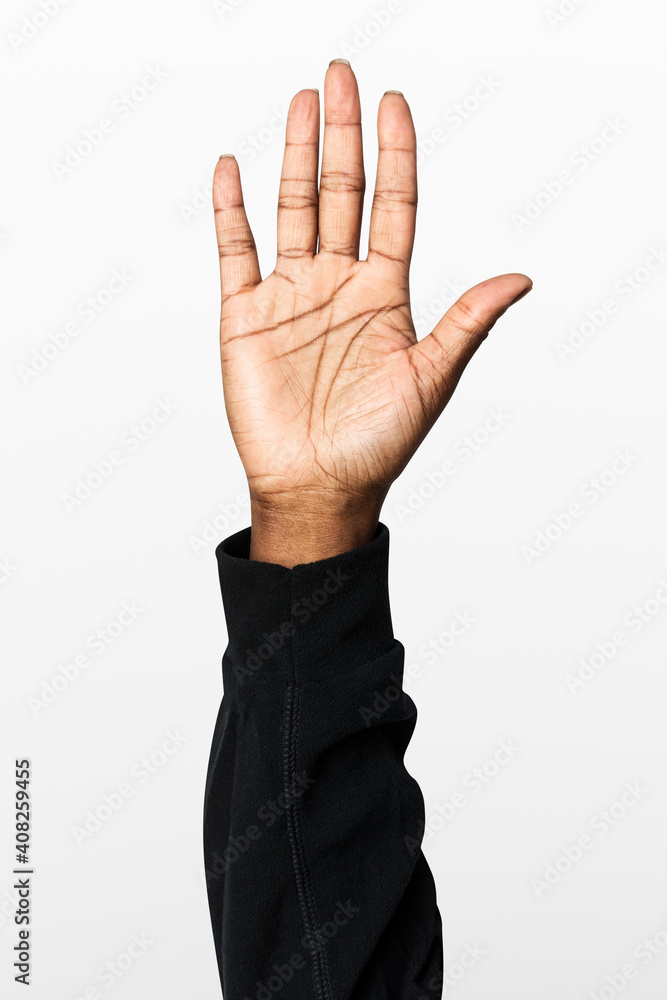 Hand showing palm gesture with black long sleeve