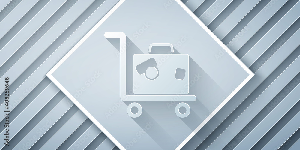 Paper cut Hotel luggage cart with suitcase icon isolated on grey background. Traveling baggage sign.