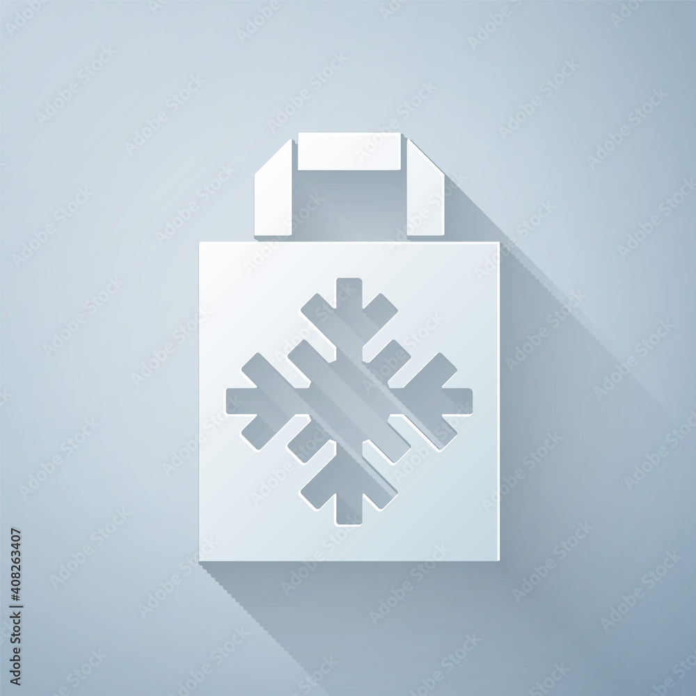 Paper cut Christmas paper shopping bag with snowflake icon isolated on grey background. Package sign