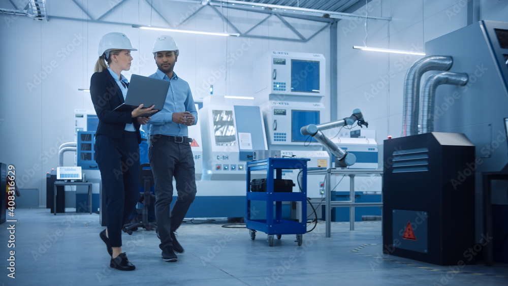 Female Chief Engineer and Male Project Manager Walk Through Modern Factory, Talking and Planning Opt