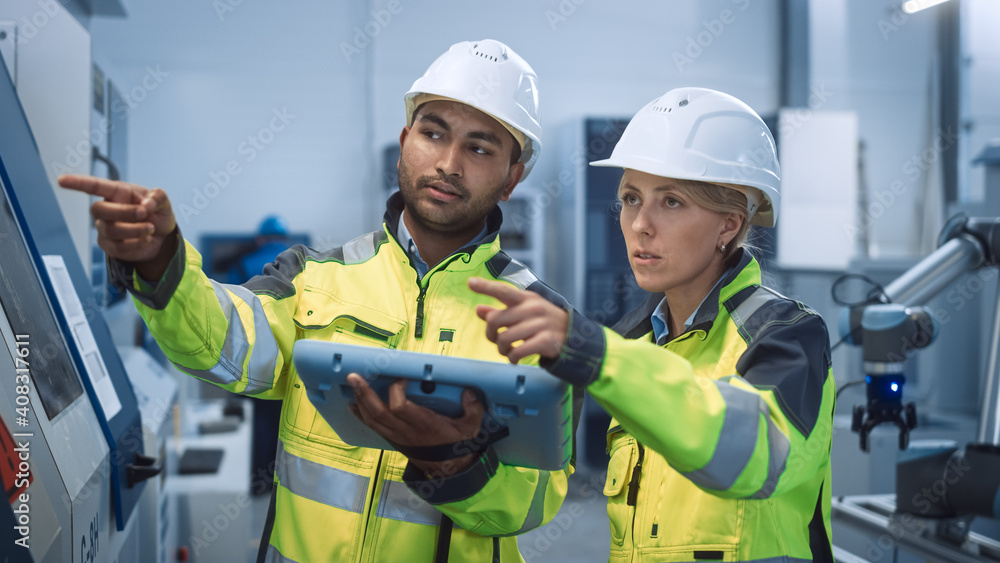 Chief Engineer and Project Manager Wearing Safety Vests and Hard Hats, Use Digital Tablet Controller