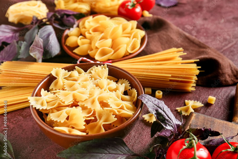 Assortment of dry pasta on color background