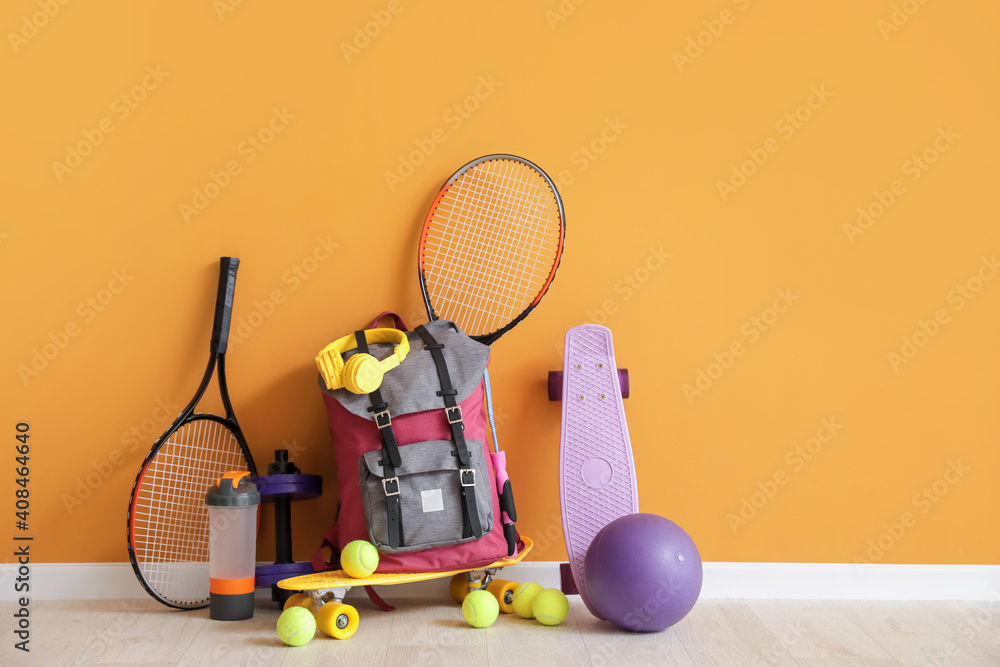 Set of sports equipment on floor near color wall