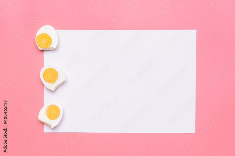 Boiled eggs and blank sheet of paper on color background