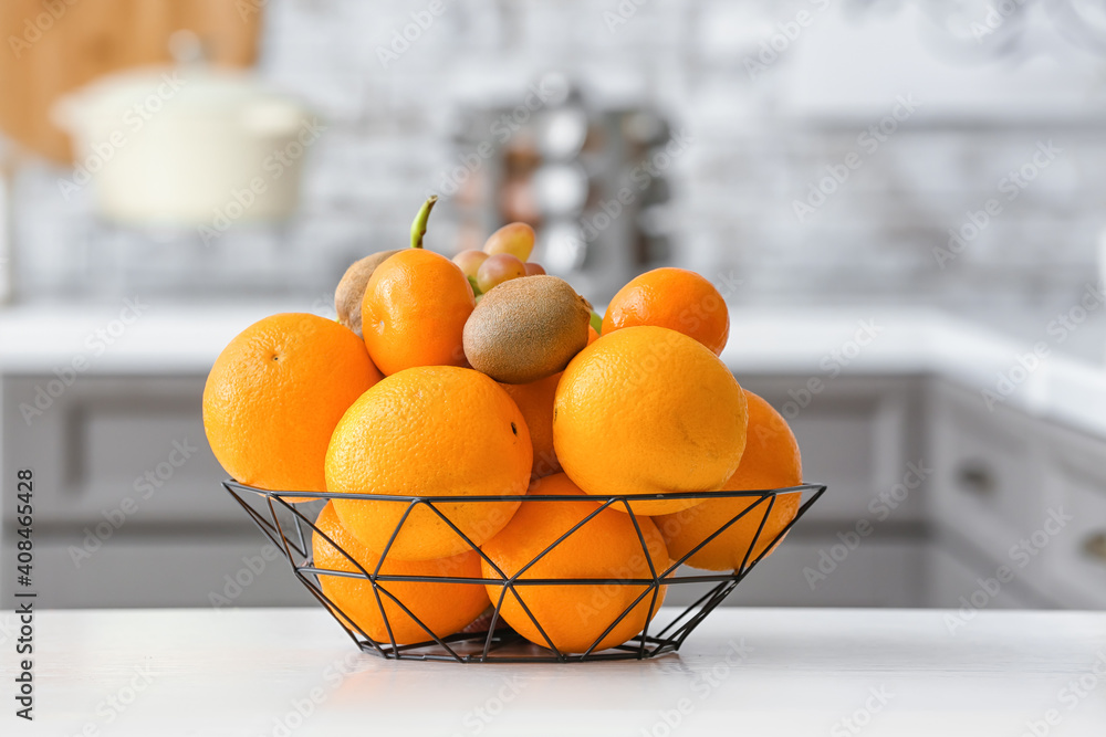 Basket with different fruits on kitchen table