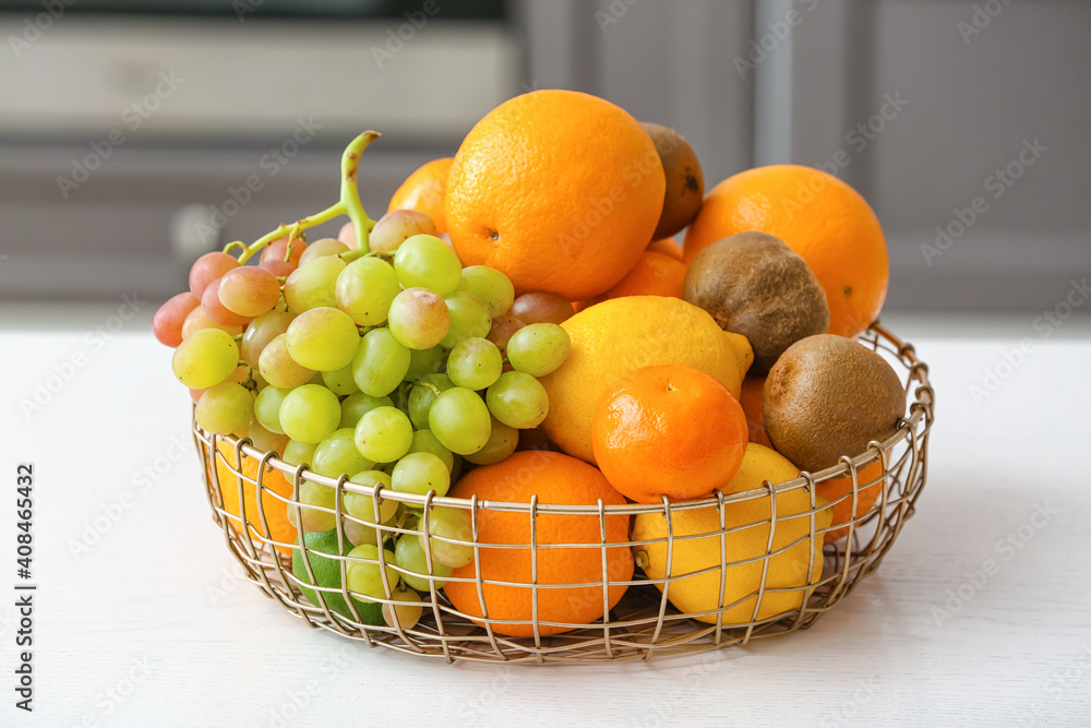 Basket with different fruits on kitchen table