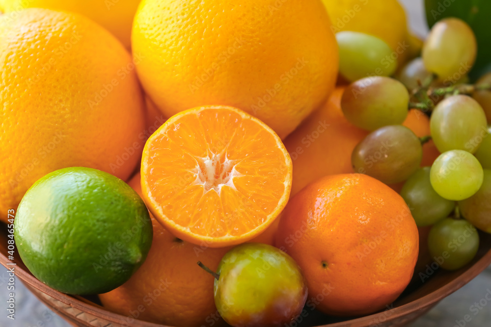 Bowl with different fruits on table, closeup