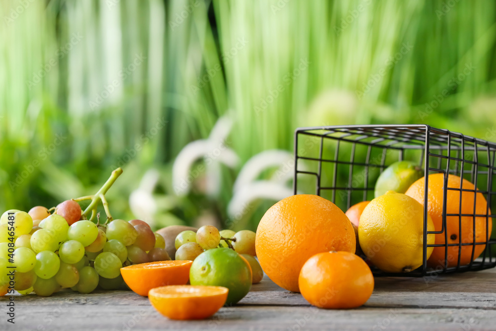 Basket with different fruits on table outdoors