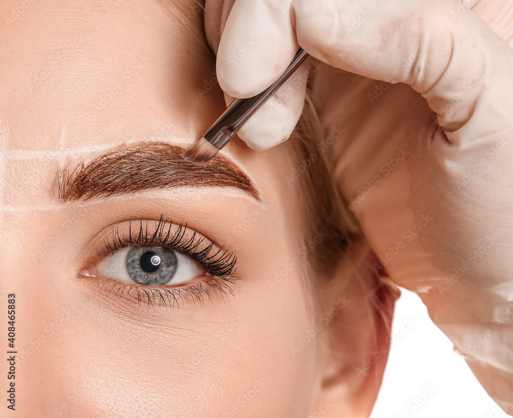 Young woman undergoing eyebrow correction procedure, closeup