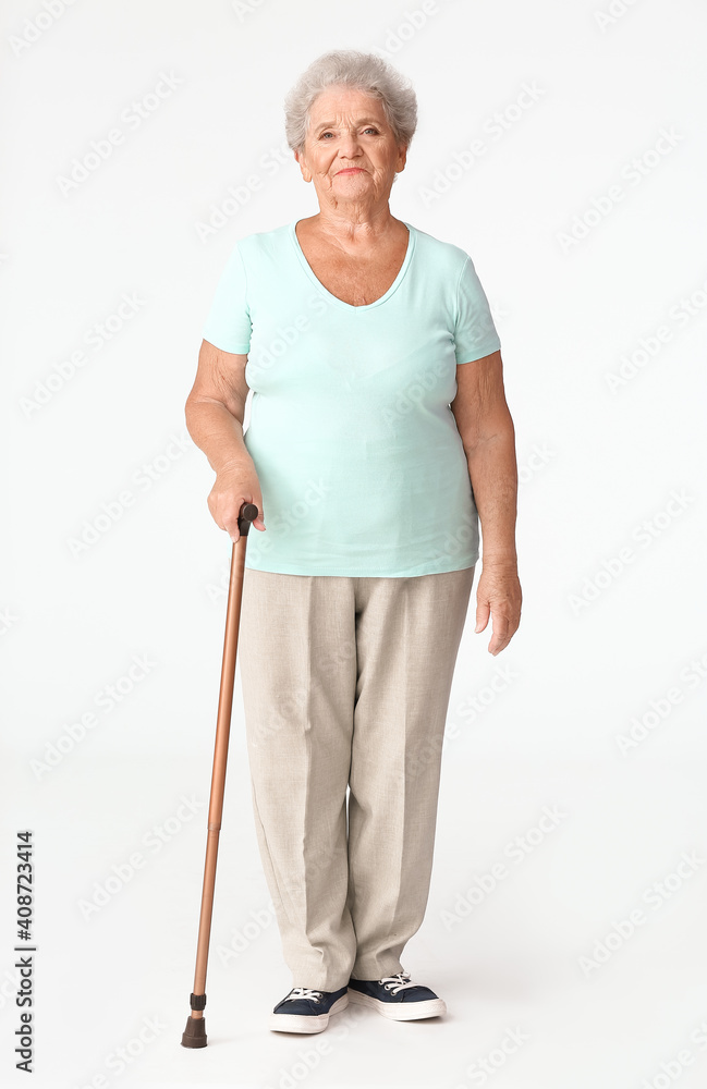 Senior woman with walking stick on white background