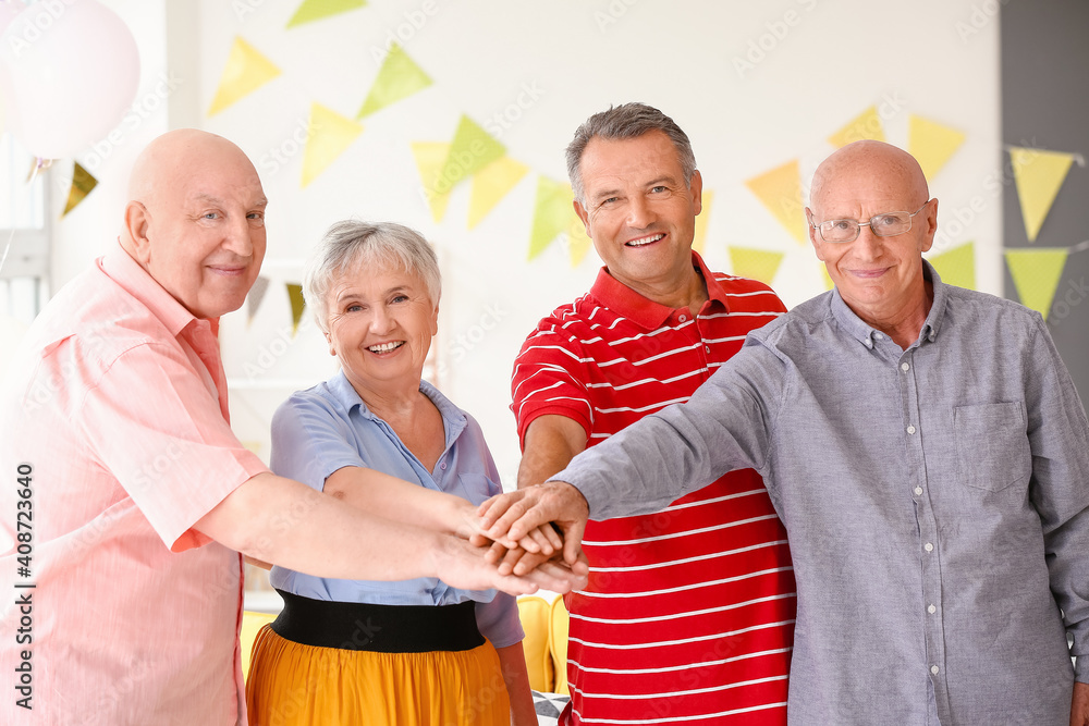 Senior people putting hands together at home