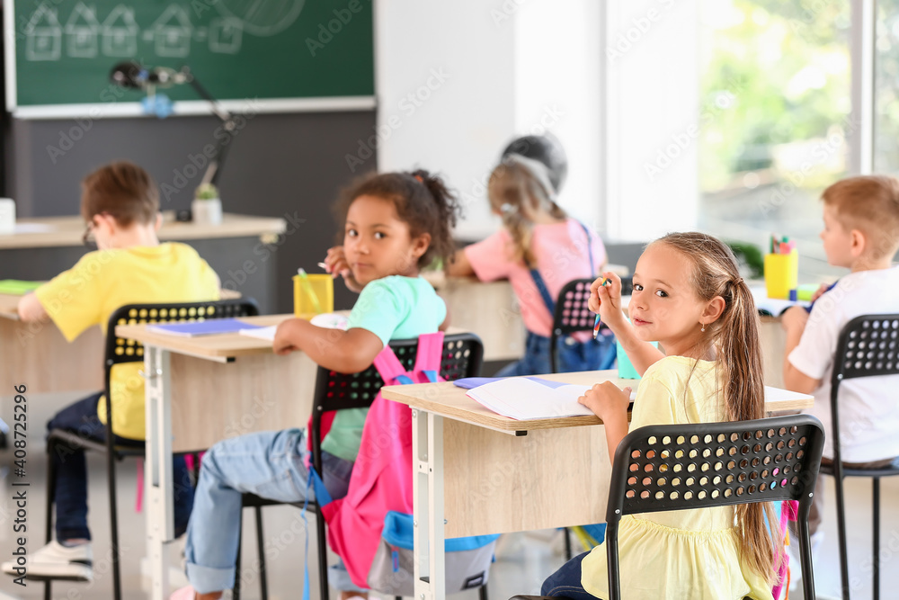 Cute pupils during lesson in classroom