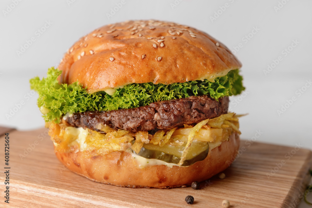 Board with tasty burger on table