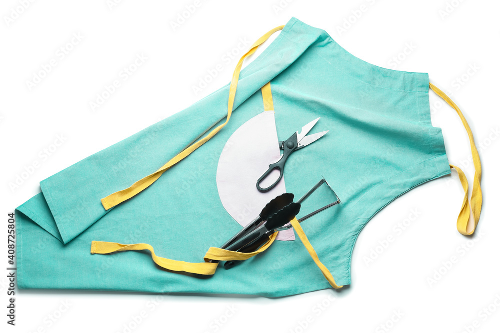 Apron and set of kitchen utensils on white background