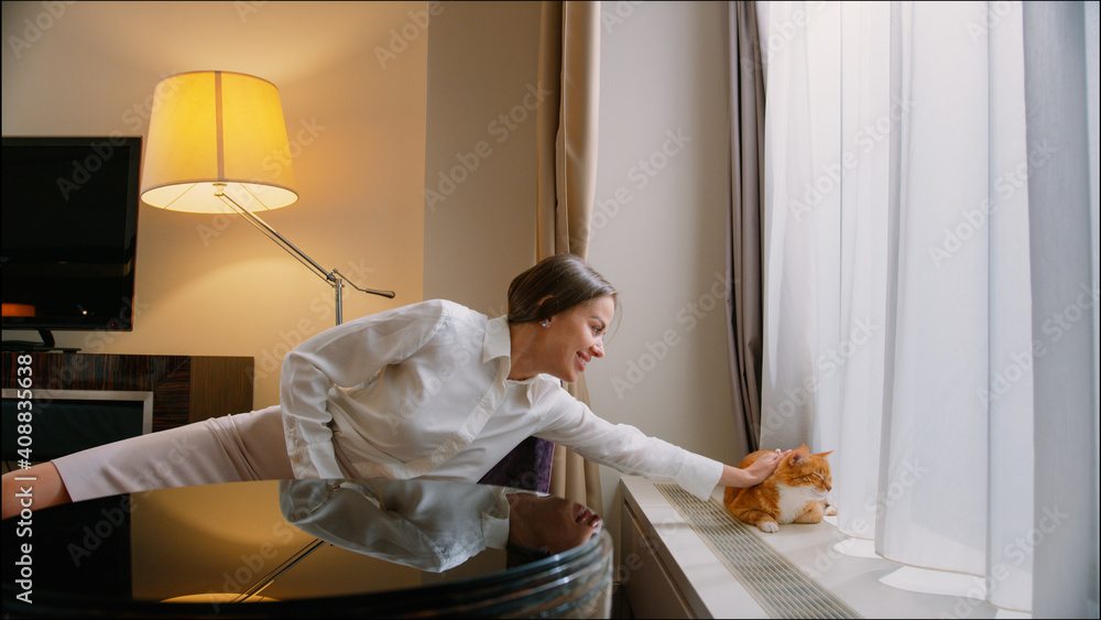 Young woman touching red cat