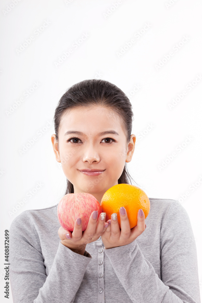 Oriental fashion woman holding red apple and orange