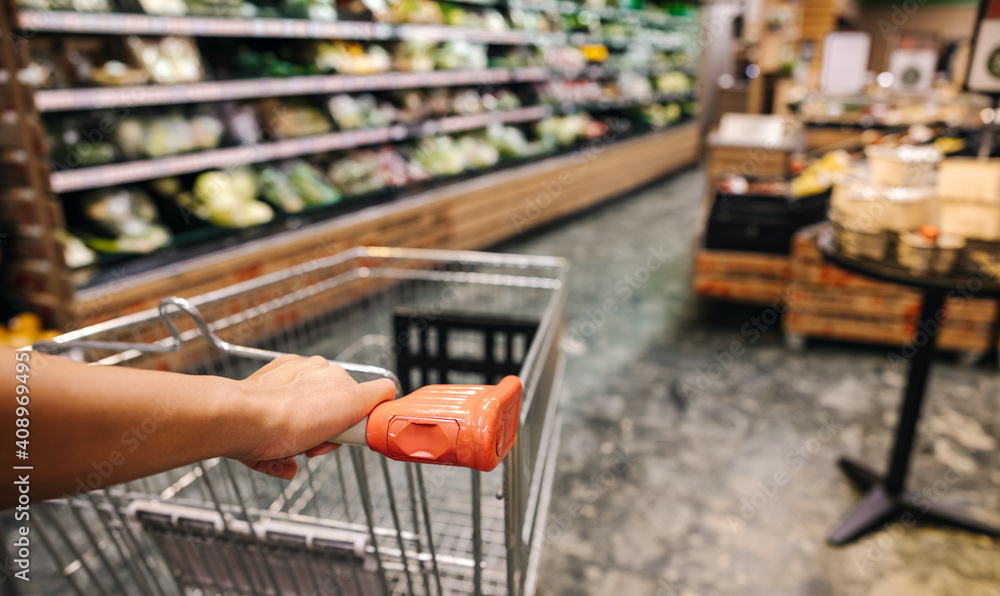 Customer with shopping cart in supermarket